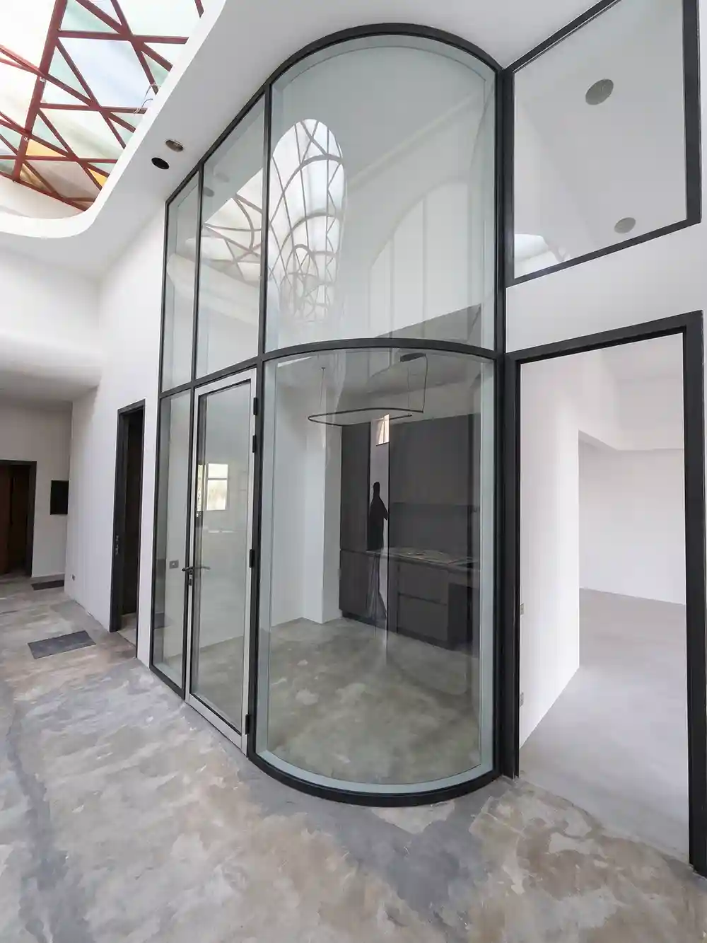 Two-level curved glass partition in a dark aluminium frame