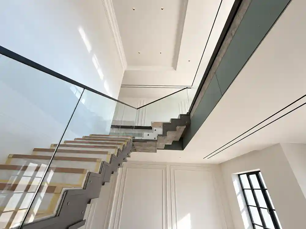 Glass stair and gallery balustrades with a dark aluminium-framed window